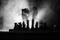 Man playing chess. Scary blurred silhouette of a person at the chessboard with chess figures. Dark toned foggy background.