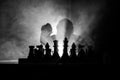 Man playing chess. Scary blurred silhouette of a person at the chessboard with chess figures. Dark toned foggy background.