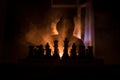 Man playing chess. Scary blurred silhouette of a person at the chessboard with chess figures. Dark toned foggy background