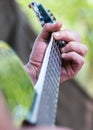 Man playing classical acoustic guitar sitting near tent outdoor. Closeup of hands. Vertical orientation. Selective focus Royalty Free Stock Photo