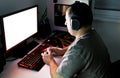 Man playing computer game on custom made desktop with joypad, keyboard, mouse.