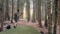 Man playing disc golf in the forest in Norway with a beautiful landscape