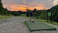 Man playing disc golf at the Krokhol Disc Golf Course in Norway against a golden sunset