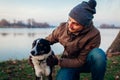 Man playing with dog in autumn park by lake. Happy pet having fun outdoors Royalty Free Stock Photo