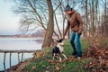 Man playing with dog in autumn park by lake. Happy pet having fun outdoors Royalty Free Stock Photo