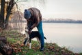 Man playing with dog in autumn park by lake. Happy pet having fun walking outdoors Royalty Free Stock Photo