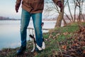 Man playing with dog in autumn park by lake. Happy pet having fun walking outdoors hugging its owner`s leg Royalty Free Stock Photo