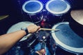 Man playing the drum set with wooden drumsticks in music room Royalty Free Stock Photo