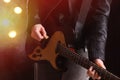 Man playing electric guitar on stage, closeup. Rock concert Royalty Free Stock Photo