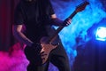 Man playing electric guitar on stage, closeup. Rock music Royalty Free Stock Photo