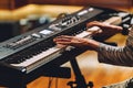 Man playing electronic musical keyboard synthesizer ny hands on white and black keys in recording studio Royalty Free Stock Photo