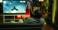 Man playing entertaining spaceship flying videogame on large smart TV
