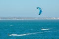 The man playing extreme action by jumping above the sea water with kitesurfing board in green color at Brighton le sands beach.