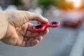 Man playing with fidget spinner stress relieving toy outdoors on city street