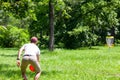 Man playing flying disc golf sport game in the public park or nature