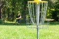 Man playing flying disc sport game in the park, chain basket in the focus Royalty Free Stock Photo
