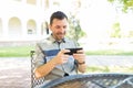 Man Playing Games On Smartphone While Sitting In Garden