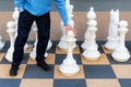 Man playing gigantic chess outdoors. Outdoor chess board with big plastic pieces. Giant size chess in public area zone. Close up Royalty Free Stock Photo