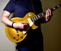 Man playing a gold top electric guitar with P90 pickups. Royalty Free Stock Photo