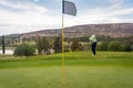 Man playing golf hitting the ball onto the green Royalty Free Stock Photo