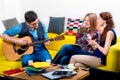 Man playing a guitar with girlfriends Royalty Free Stock Photo