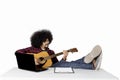 Man playing guitar with laptop on table Royalty Free Stock Photo