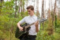 A man is playing a guitar outdoor