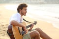 Man playing guitar sitting on the beach Royalty Free Stock Photo