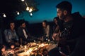Man playing a guitar to his friends while camping Royalty Free Stock Photo