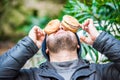 Man playing with his food - placing his hamburgers on his face - front view Royalty Free Stock Photo