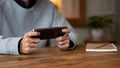 A man playing a mobile game or watching a video on his smartphone while relaxing in a coffee shop Royalty Free Stock Photo