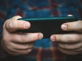 Man playing mobile video game, close up of hands holding smartphone Royalty Free Stock Photo