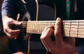 Man playing music at black wooden acoustic guitar
