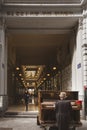 Man playing the piano at the entrance to the Passage du Nord in Brussels and people passing by