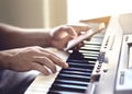 Man playing piano and using mobile phone. Person recording sound, reading notes from smartphone screen or writing lyrics.