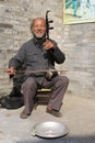 A man is playing the traditional musical instrument which is called Erhu or Nanhu and sounds like a violin, China