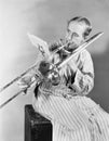 Man playing trombone in nightgown Royalty Free Stock Photo