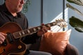 Man playing a vintage jazz guitar at home