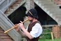 Man playing wooden medieval flute in reenactment