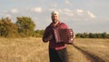 Man plays accordion in sun. Artist performs in open air, sings and plays musical instrument. Tradition and celebration Royalty Free Stock Photo