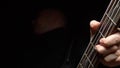 Man plays the bass guitar. Dark background. slowmo Royalty Free Stock Photo