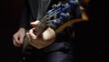 Man plays the bass guitar. Dark background. slowmo Royalty Free Stock Photo