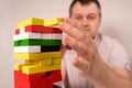 A man plays a board game of jenga, carefully pulls multi-colored blocks out of the tower. May 22, Zaporozhye, Ukraine Royalty Free Stock Photo