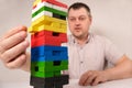 A man plays a board game of jenga, carefully pulls multi-colored blocks out of the tower. May 22, Zaporozhye, Ukraine Royalty Free Stock Photo