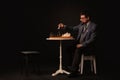 A man plays chess and smokes a pipe on a dark background