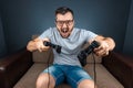 A man plays the console, video games react strongly and emotionally while sitting on the couch. Day off, entertainment, leisure