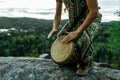 Man plays djembe on the top of a mountain