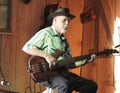 Man plays electric guitar in a barn during a festival