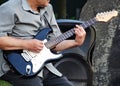 A man plays electric guitar in the street. Street musician