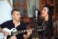 Man plays guitar and woman sings next to beach Royalty Free Stock Photo